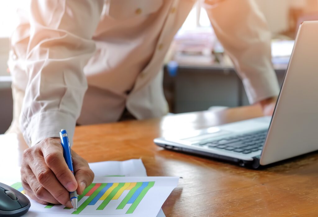 Pen in hand, Man office staff are analyzing graphs.